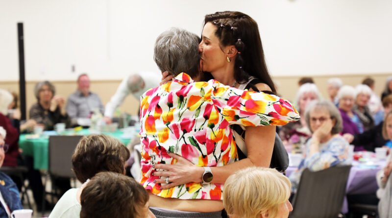 A mother and daughter hug.