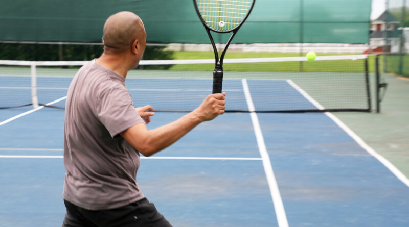 A photo of a man playing tennis.