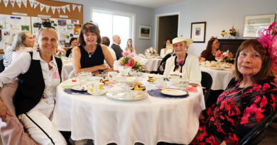 People having tea pose for a photo.
