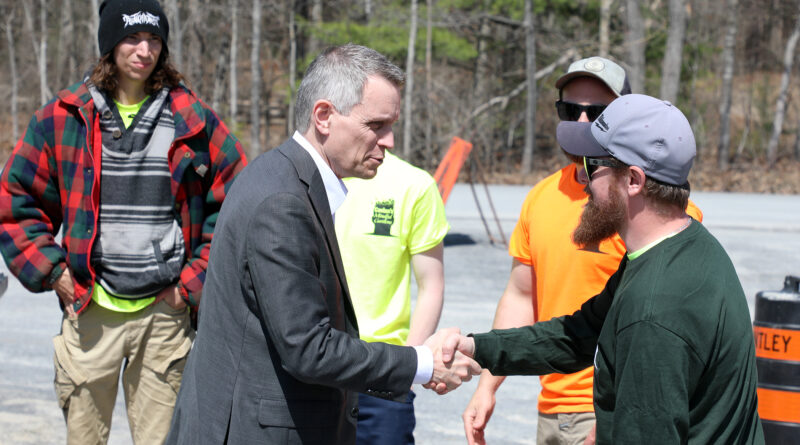 A man shakes hands with another.