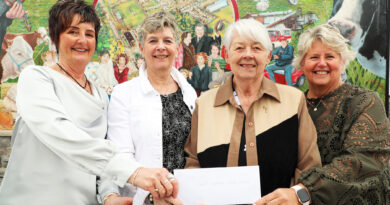 Four women hold a cheque.