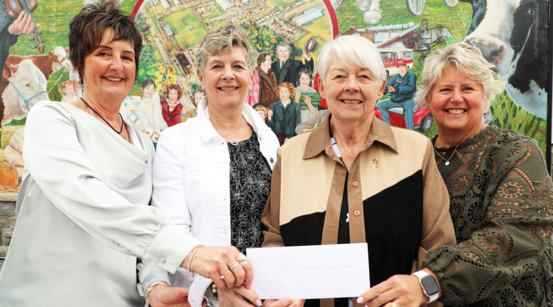 Four women hold a cheque.