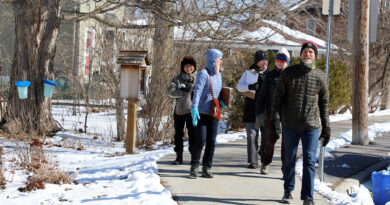A group of people walk down a road.