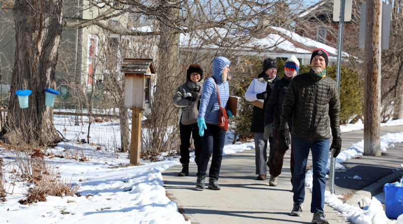 A group of people walk down a road.