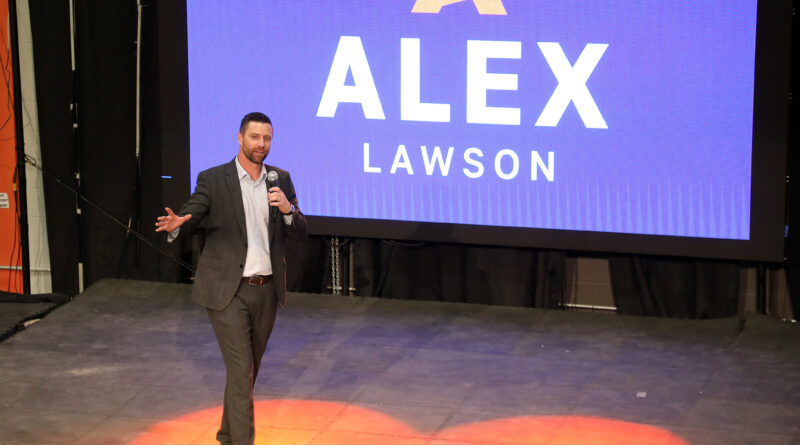 A man speaks in front of an electronic election sign.