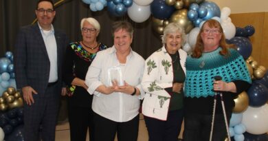 A group poses for a phot owith an award.
