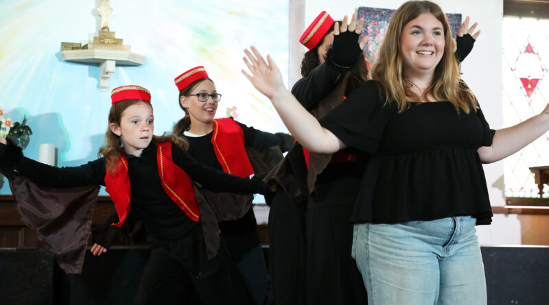 A group of women perform on a stage.
