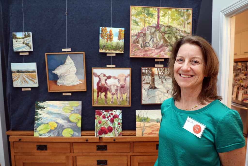 An artist poses in front of her work.