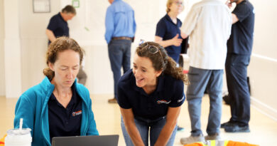 WCDR holds WC wildfire exercise Two people chat by a computer.