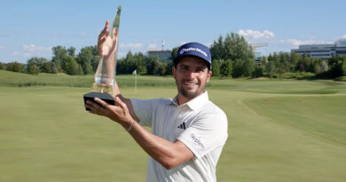A man holds up a trophy.