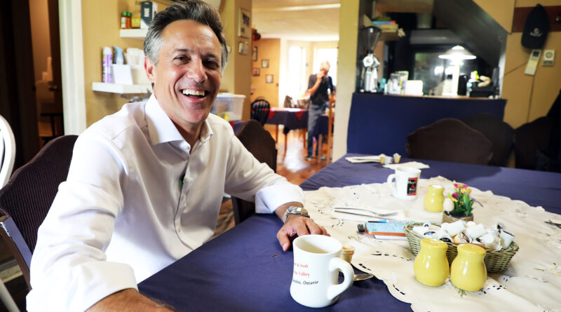 A man poses at a coffee table.