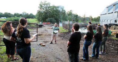 Youth Day life lessons for WC 4-H Clubs A group of people talk at a farm.